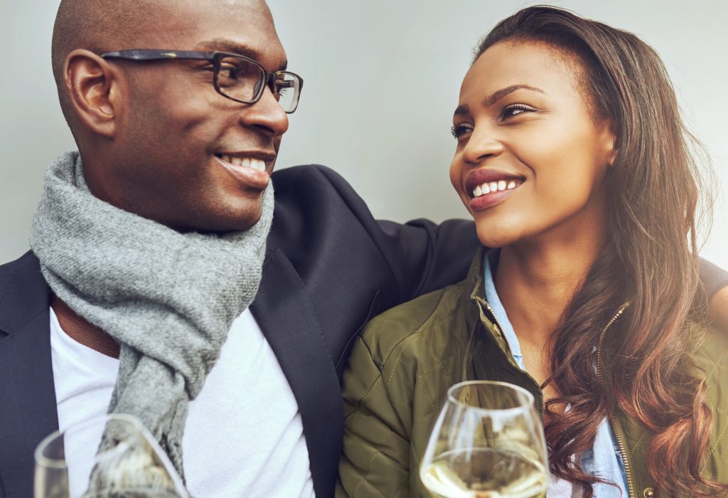 Romantic young African couple enjoying wine